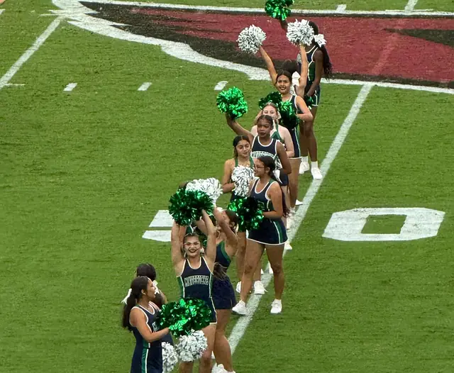 The squad lined up with poms near midfield on the Cardinals' field at State Farm Stadium, October 2025
