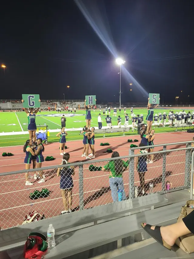 Stunt groups holding up G, H and S signs at a night game